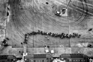 Foto em preto e branco mostra uma fila de pessoas